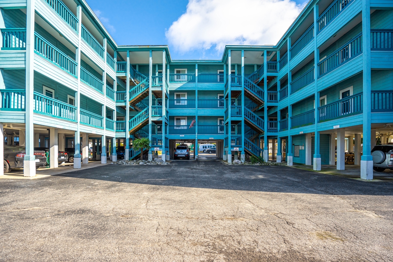 Vibrant turquoise property features convenient covered parking and easy access to your coastal getaway.