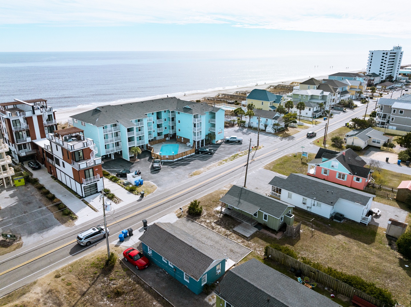 Aerial view of coastal vacation properties showcasing beachfront location with convenient beach access and nearby amenities.
