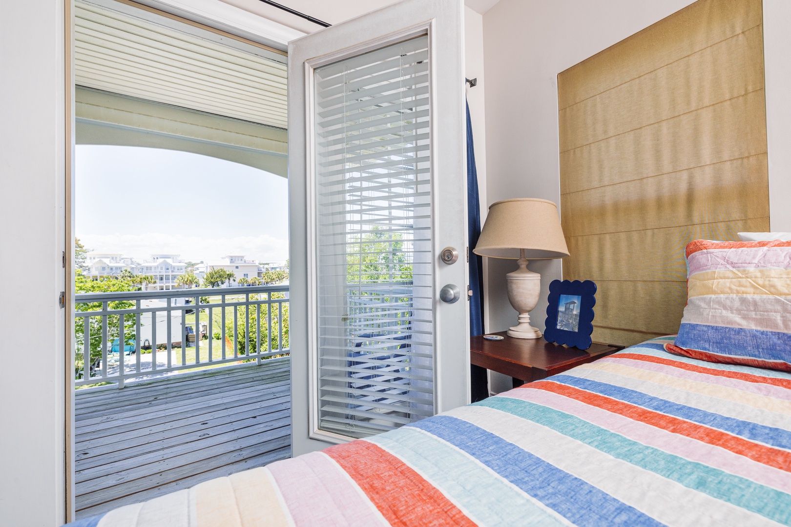 Wake up to tropical views from your comfortable bed, where colorful linens and natural light create the perfect morning retreat.