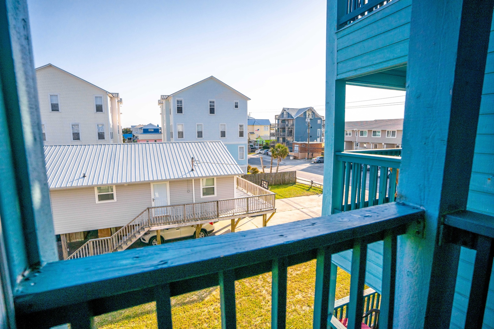 Step onto your private balcony and soak in peaceful neighborhood views while morning light filters through colorful beach homes.
