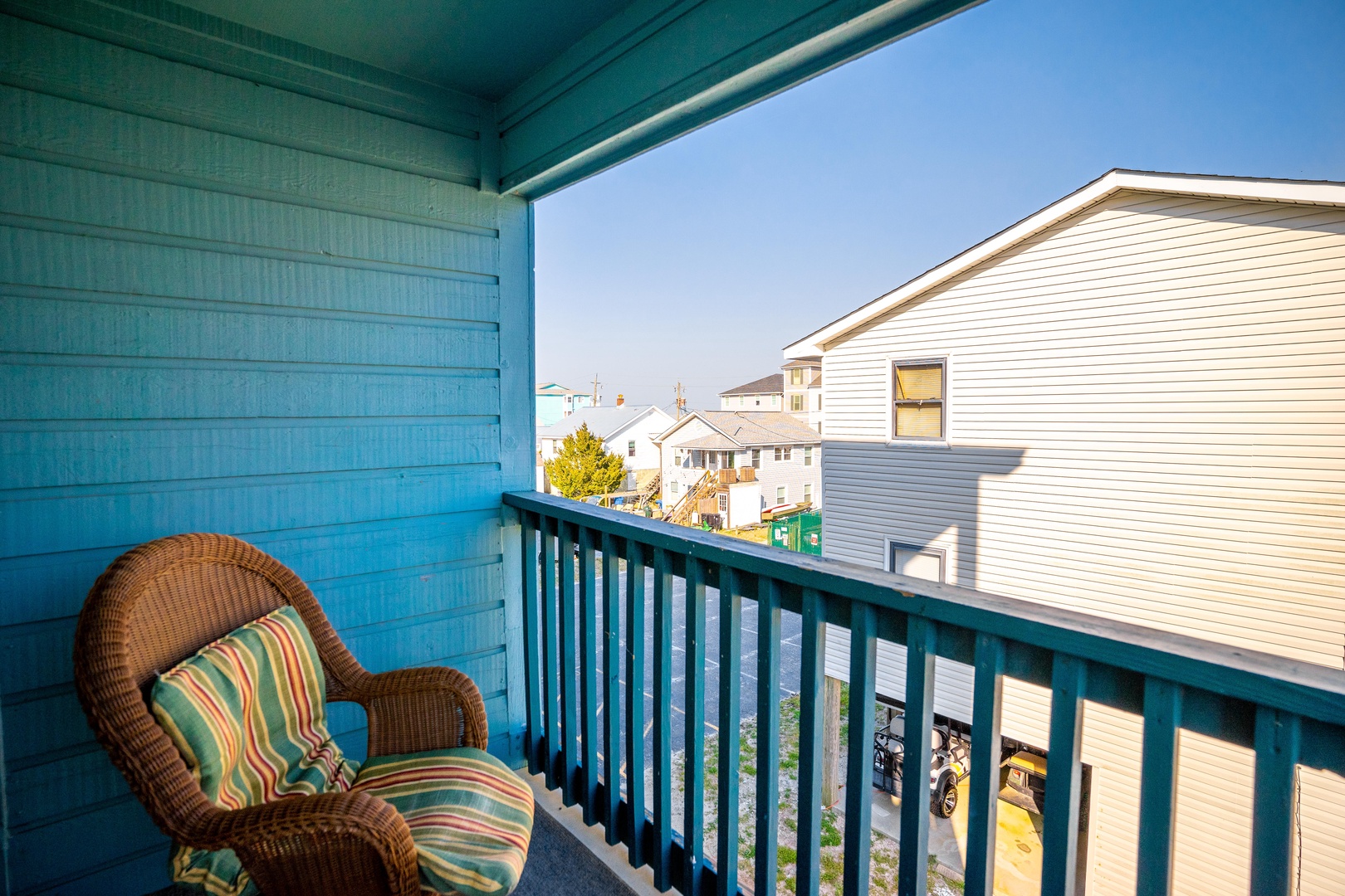 Step onto your private balcony where colorful wicker chairs await your morning coffee moments, overlooking charming neighborhood views.
