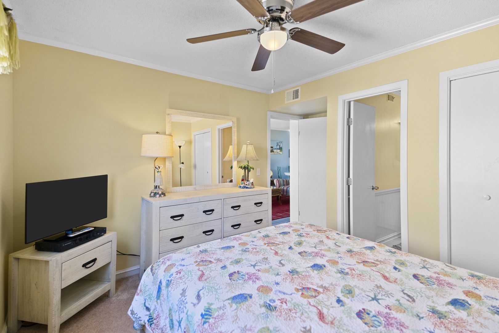 Unwind in your cheerful bedroom with ocean-themed bedding, ceiling fan for comfort, and entertainment ready on your flat-screen TV.
