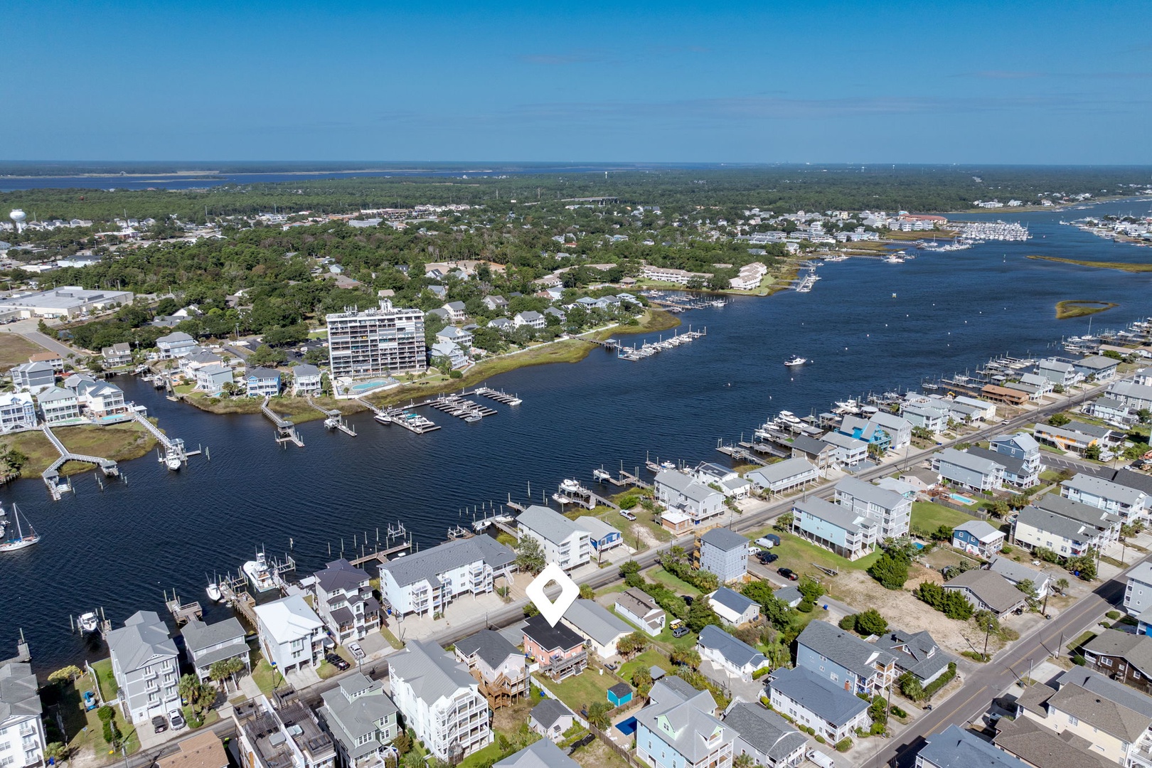 Aerial view of a coastal community with marina, waterfront homes, and boat docks along the harbor.