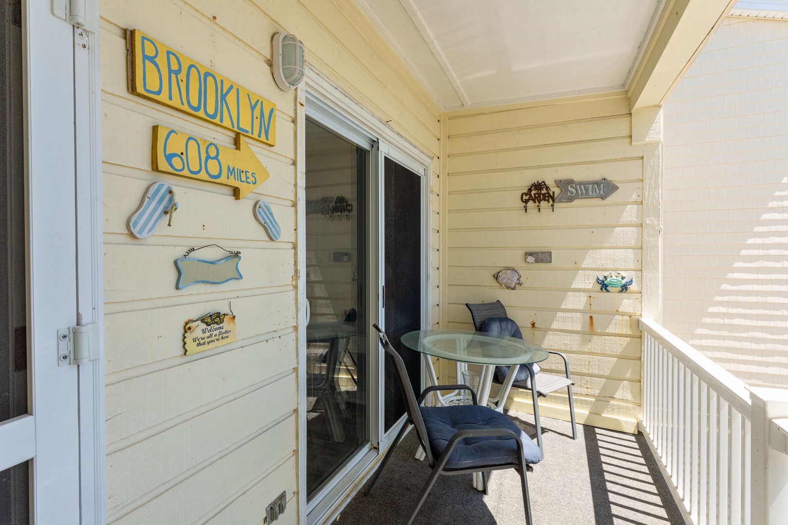 Your private balcony awaits with cozy seating and charming coastal décor—a peaceful spot to sip your morning coffee or unwind after a day of adventure.