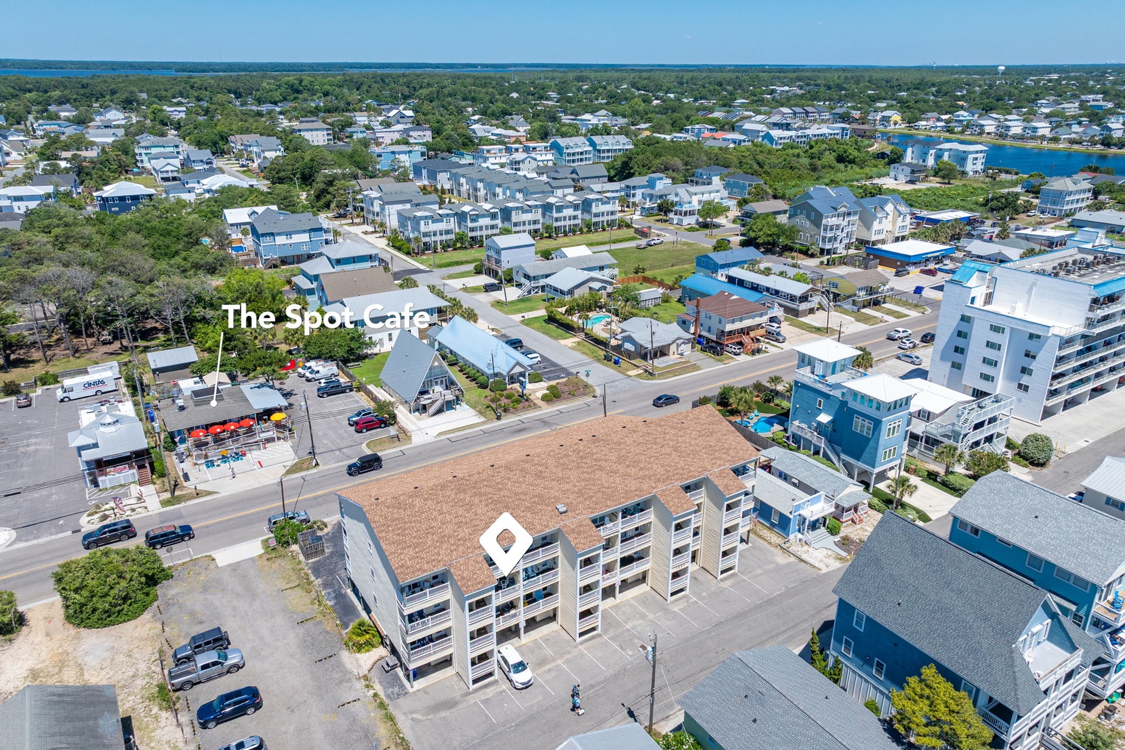 Aerial view of the coastal property nestled in a charming beach community with shops, dining, and waterways nearby—ideal for exploring during your stay.