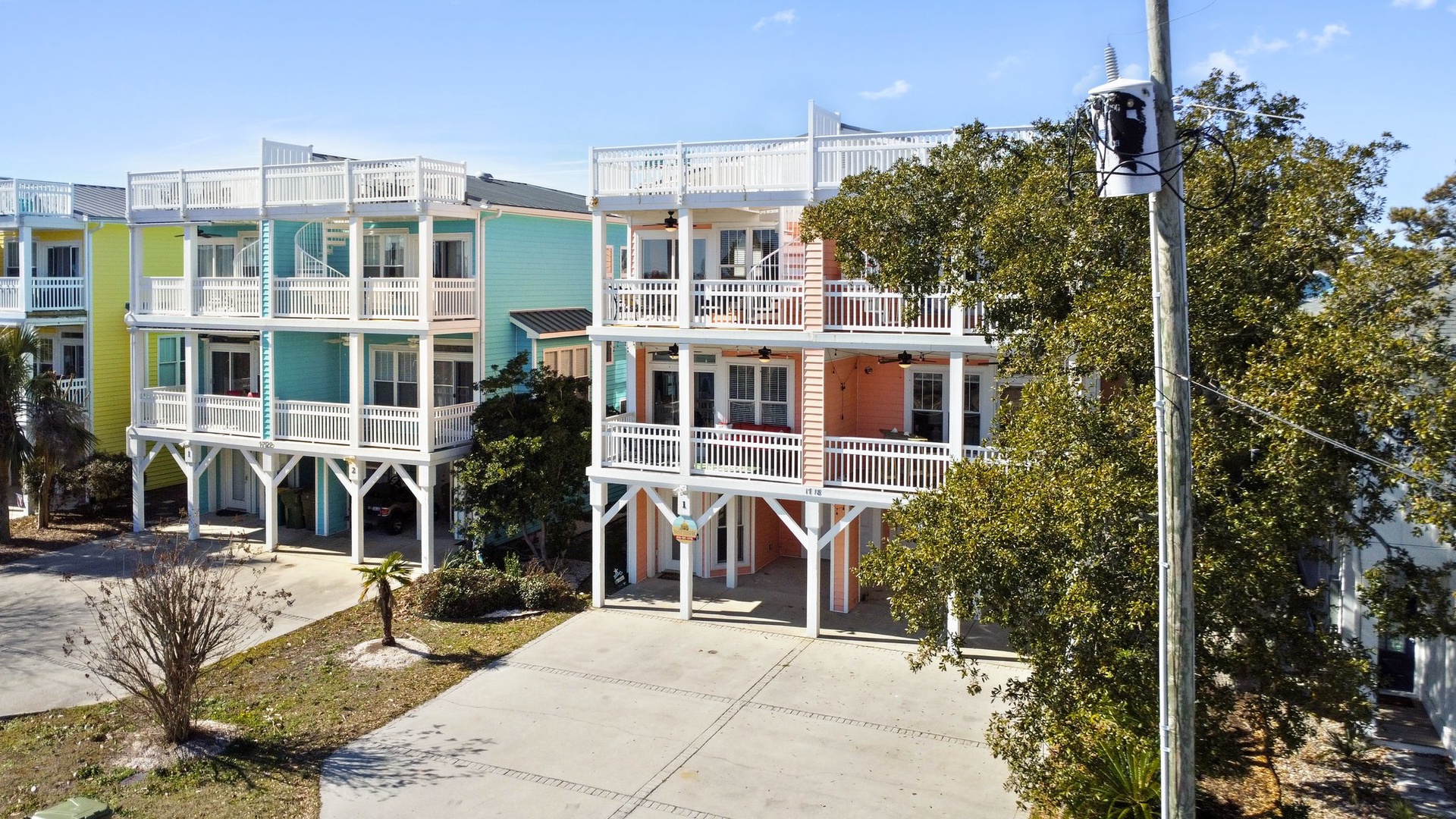 Vibrant beachside townhomes with elevated design and tropical landscaping create a welcoming coastal community atmosphere.