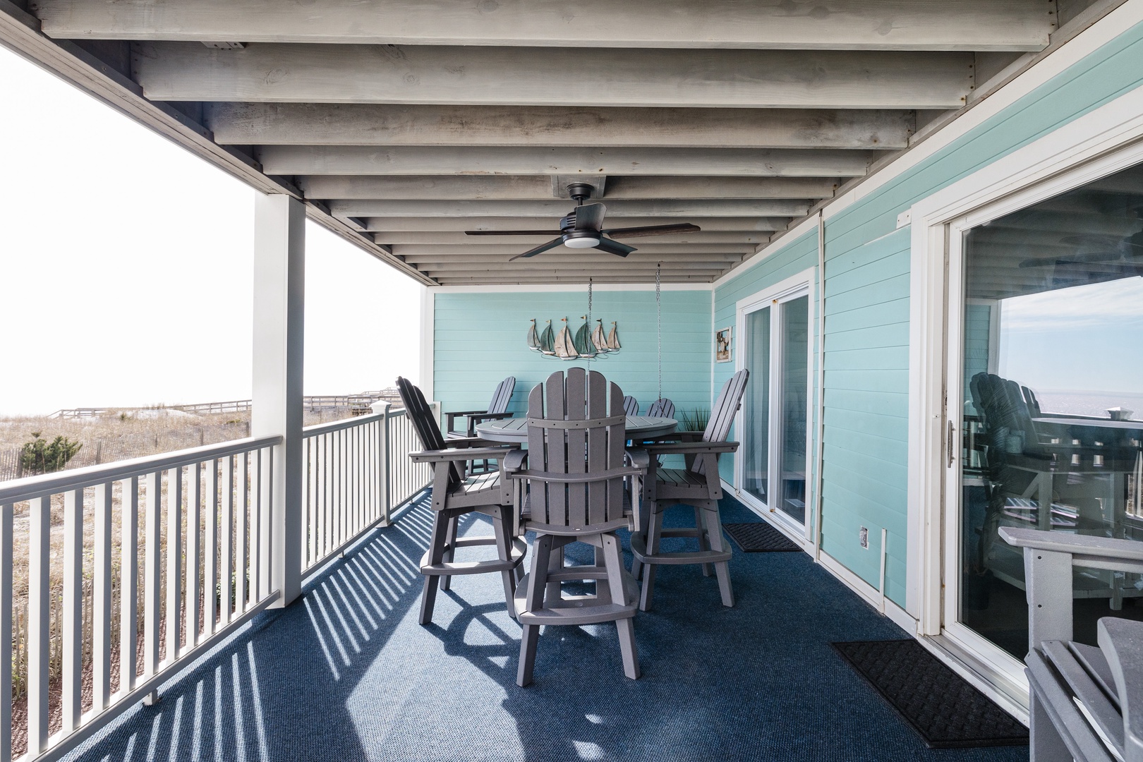 Your covered terrace offers comfortable seating and coastal charm, perfect for morning coffee or evening relaxation with ocean breezes.