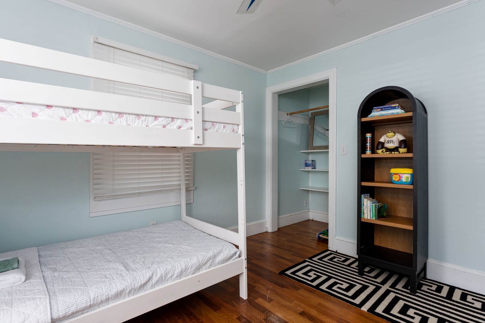 Your kids will love this cheerful bedroom with cozy bunk beds and a unique arched bookshelf filled with games and stories.