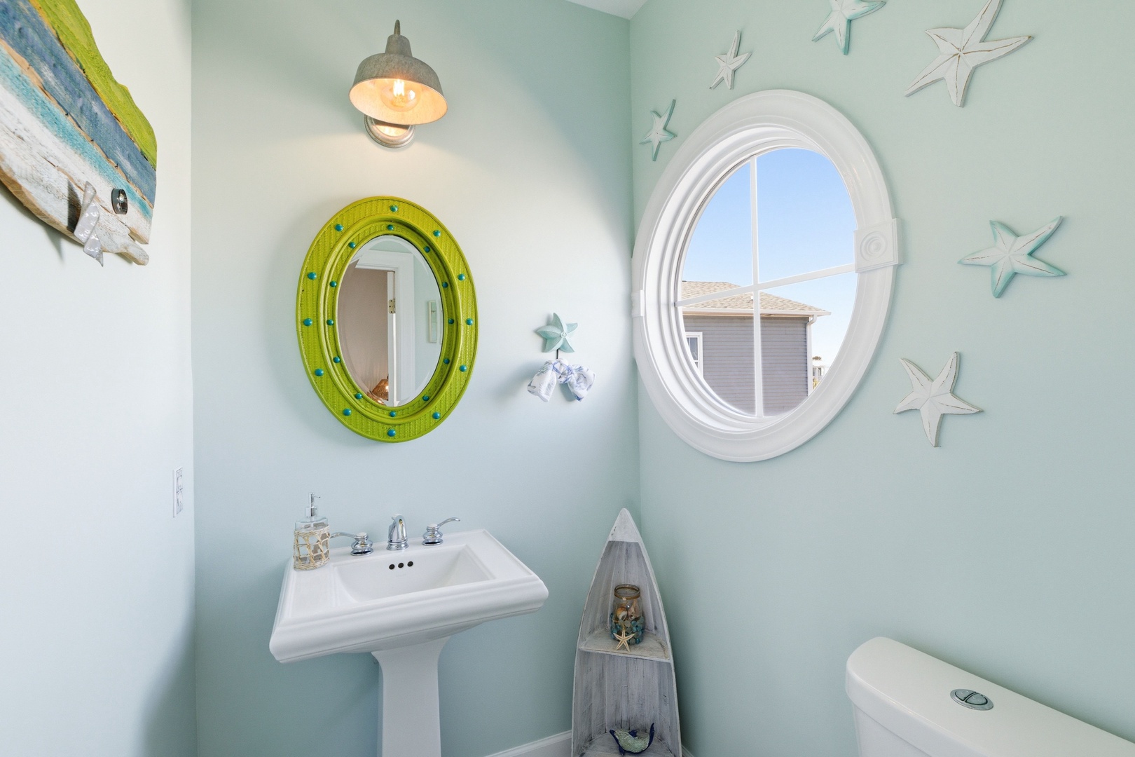 Freshen up in your charming coastal-themed bathroom, where soothing aqua walls and playful nautical touches create a relaxing seaside escape just for you.