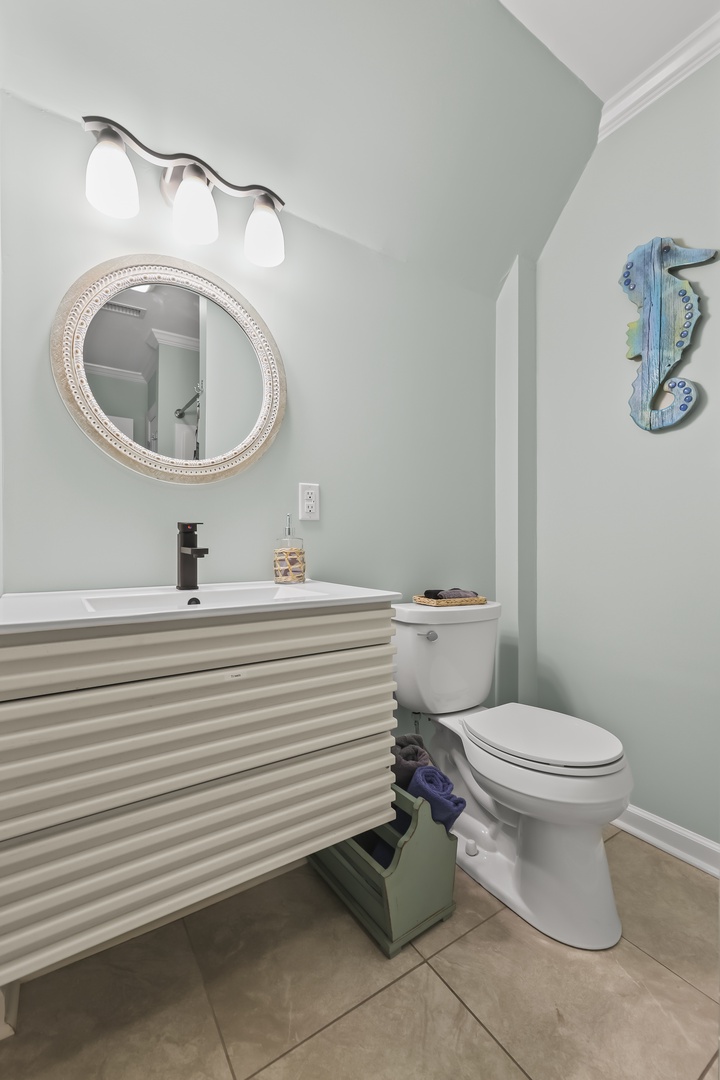 Freshen up in your coastal-inspired bathroom, complete with vanity lighting, a modern sink, and charming nautical touches that make getting ready feel like a breezy escape.