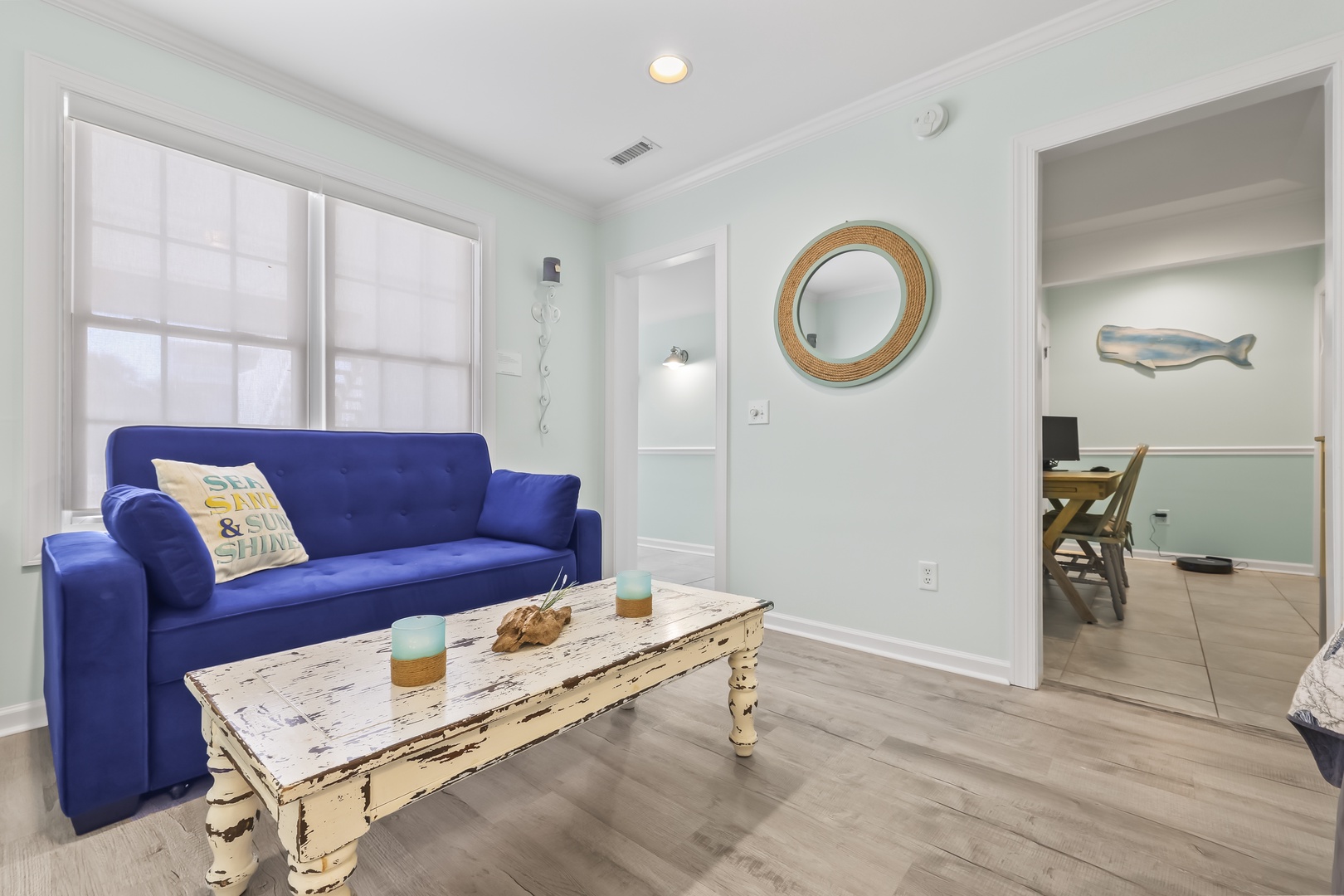 Sink into the plush blue sofa and unwind in your coastal-inspired living space, where natural light and beachy décor create a soothing retreat.