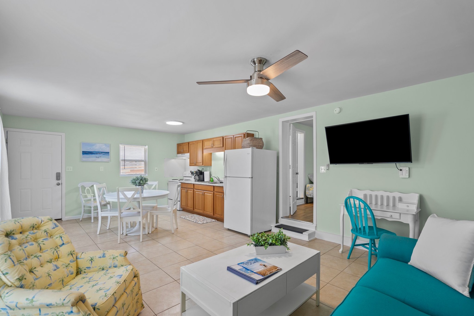 Your bright, airy living space features everything you need - full kitchen, dining area, and cozy seating with tropical touches throughout.