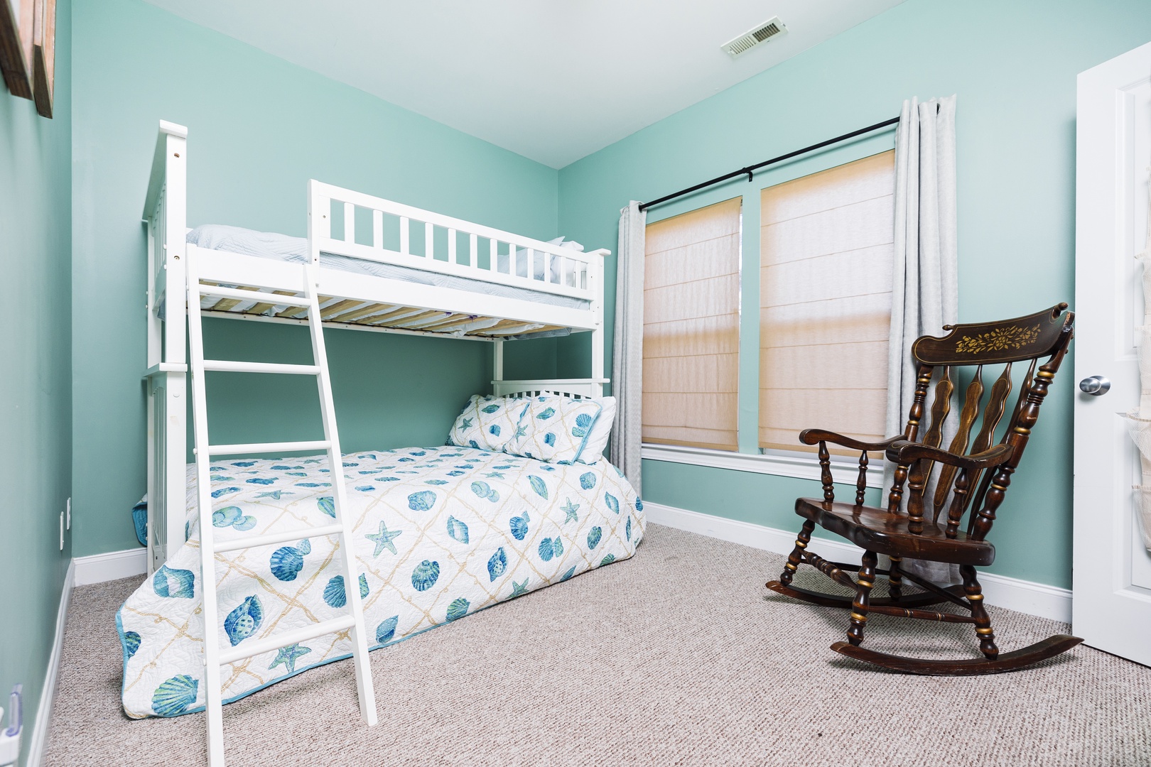 Your kids will love this charming bunk bed room with its soothing seafoam walls and cheerful seashell bedding.