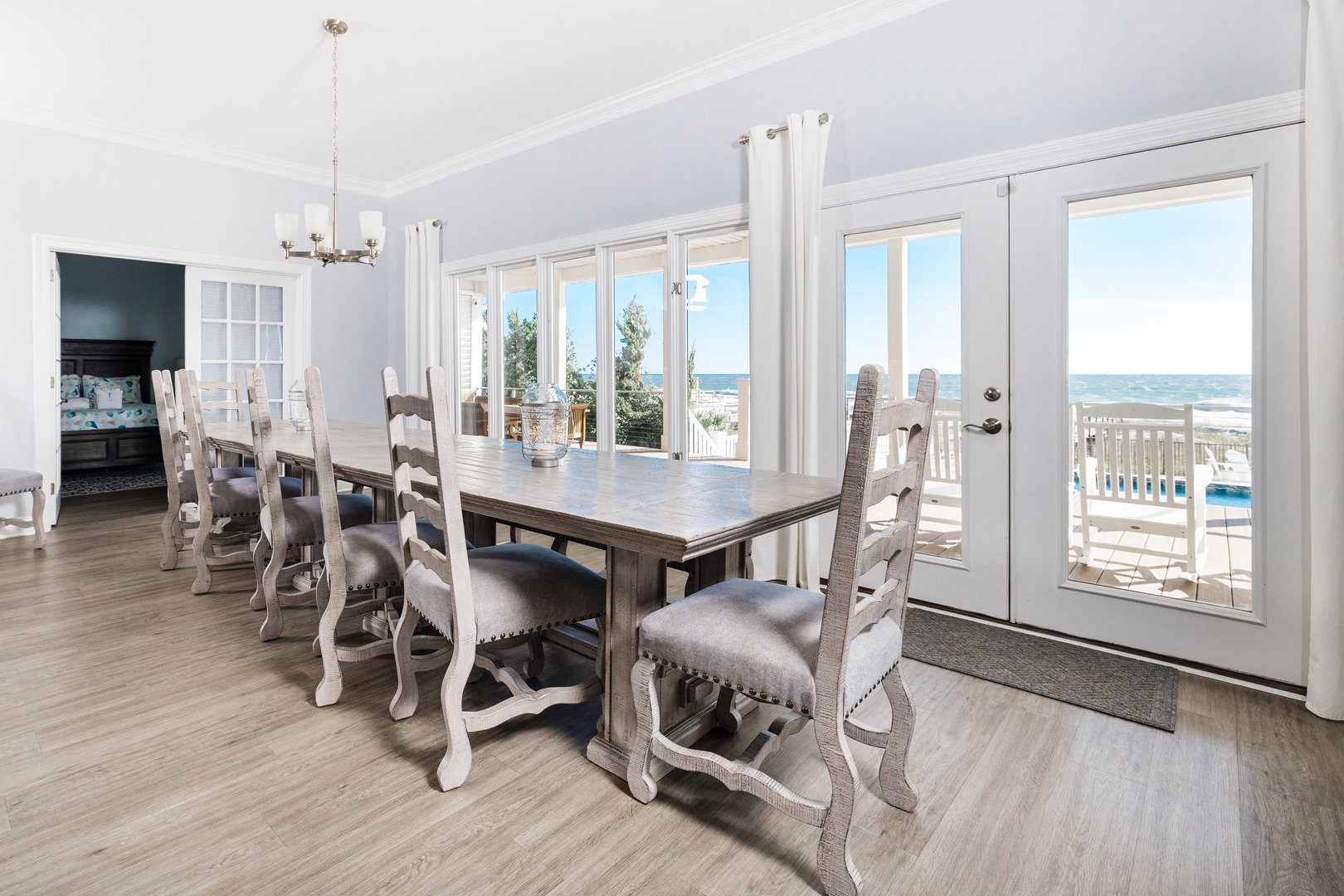 Gather around this elegant dining table where ocean views through floor-to-ceiling windows create the perfect backdrop for memorable meals with loved ones.