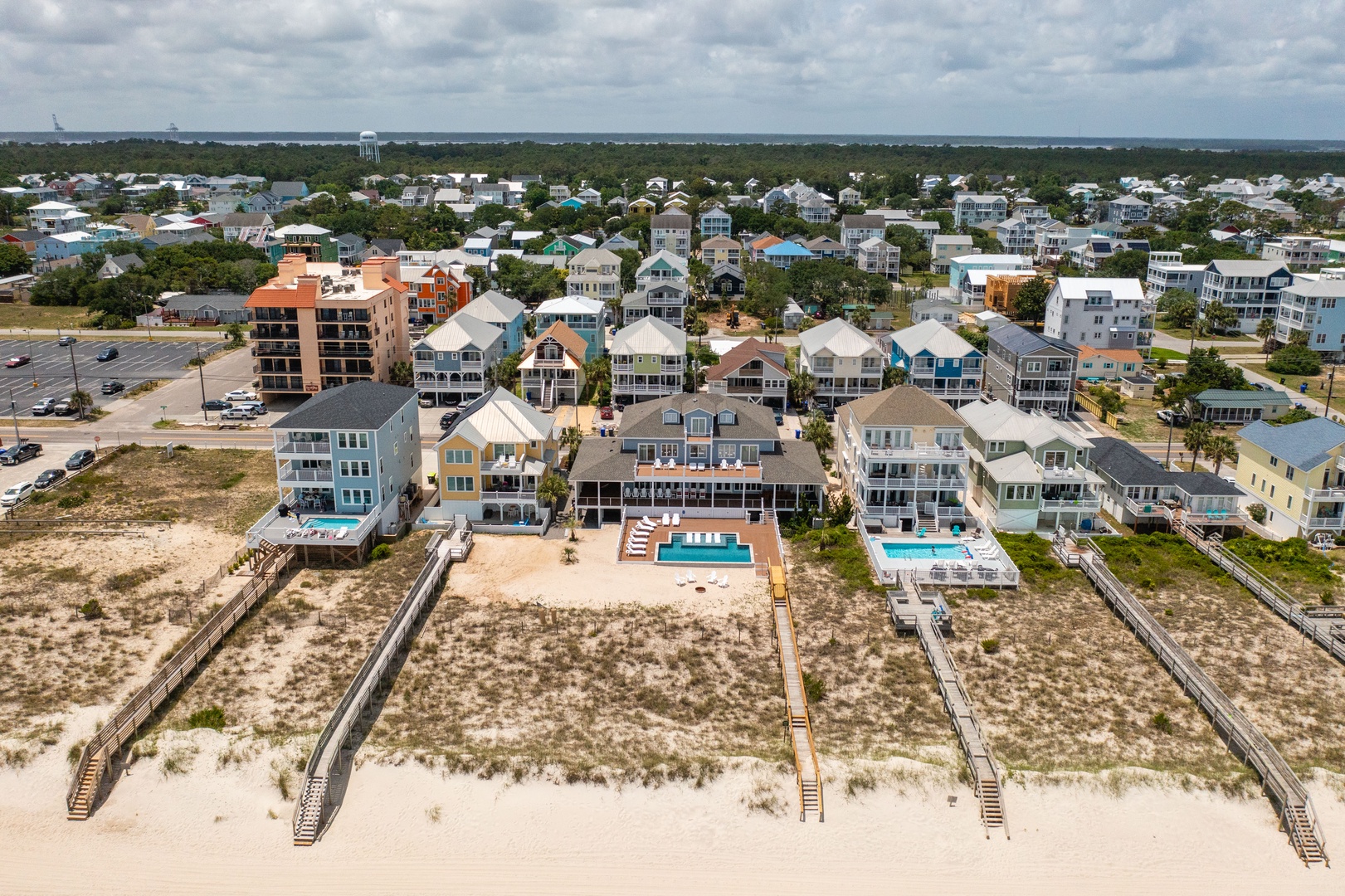 Aerial view of beachfront vacation rentals with pools and beach access walkways in a coastal community.