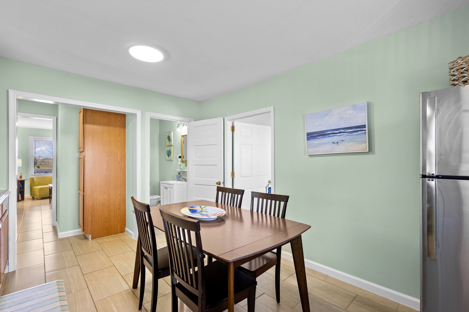 Gather around your spacious dining table in this bright, coastal-inspired space with calming mint walls and modern conveniences at your fingertips.