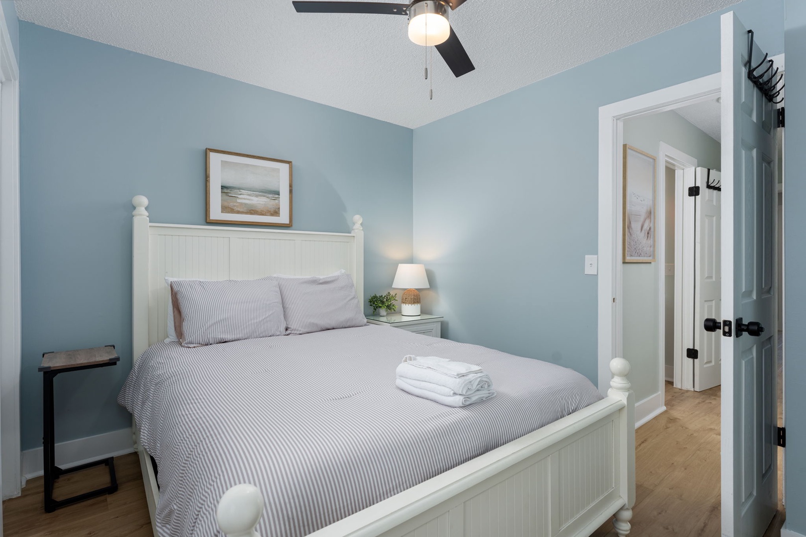 Sink into soothing coastal blue tones and crisp white linens in your peaceful bedroom retreat. Fresh towels await, art whispers of seaside calm, and soft lighting sets the perfect mood.