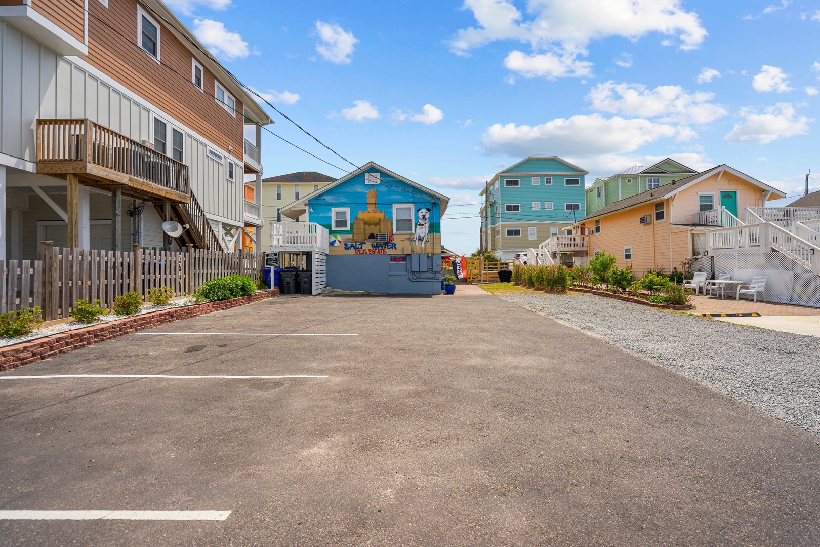 Colorful beach community with convenient parking area surrounded by charming coastal homes and nearby amenities.