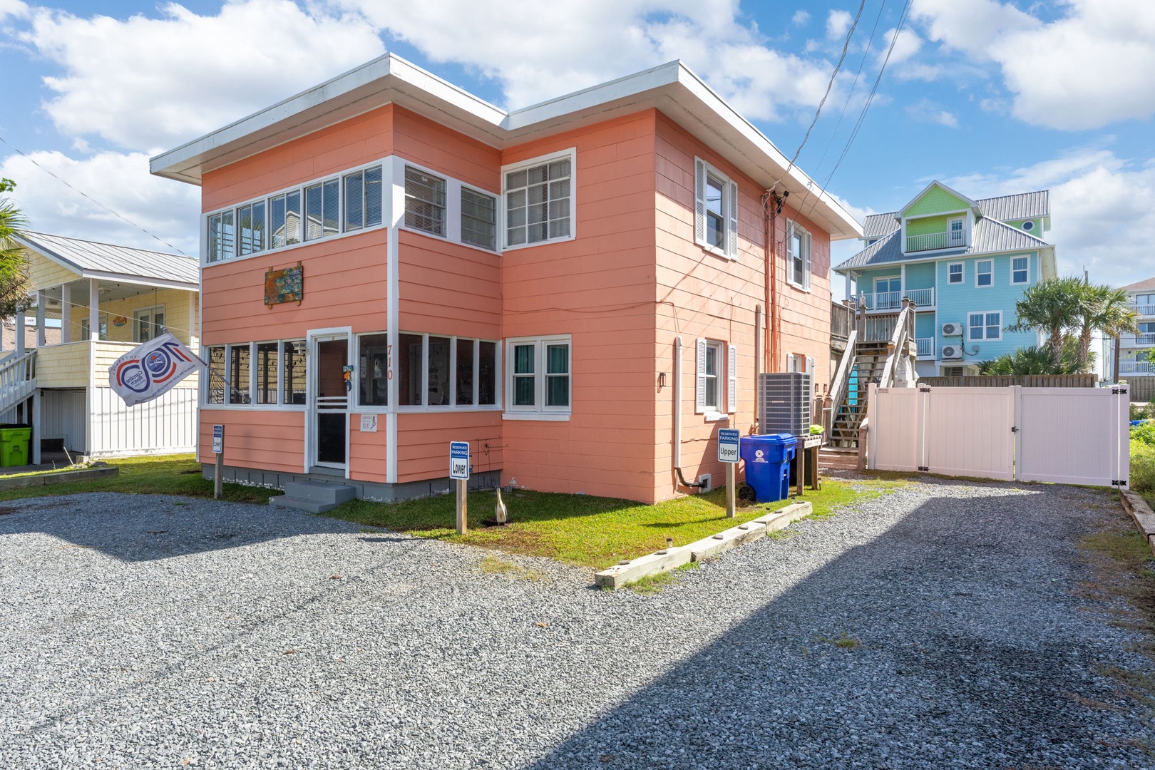 Charming coral beach house with convenient parking and colorful coastal neighbors in a vibrant seaside community.