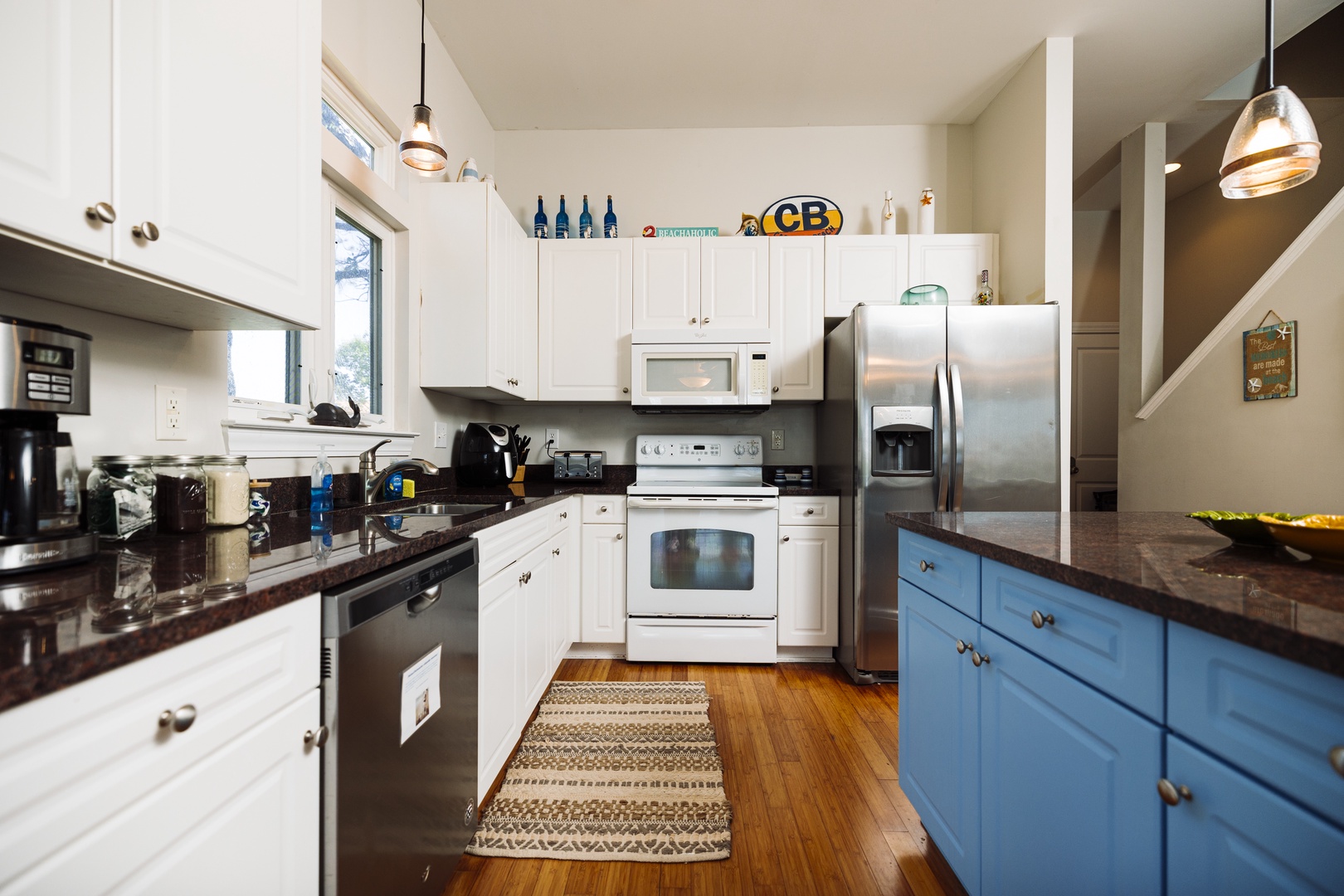 Your fully equipped kitchen features modern appliances, ample counter space, and charming blue island perfect for cooking memorable vacation meals.