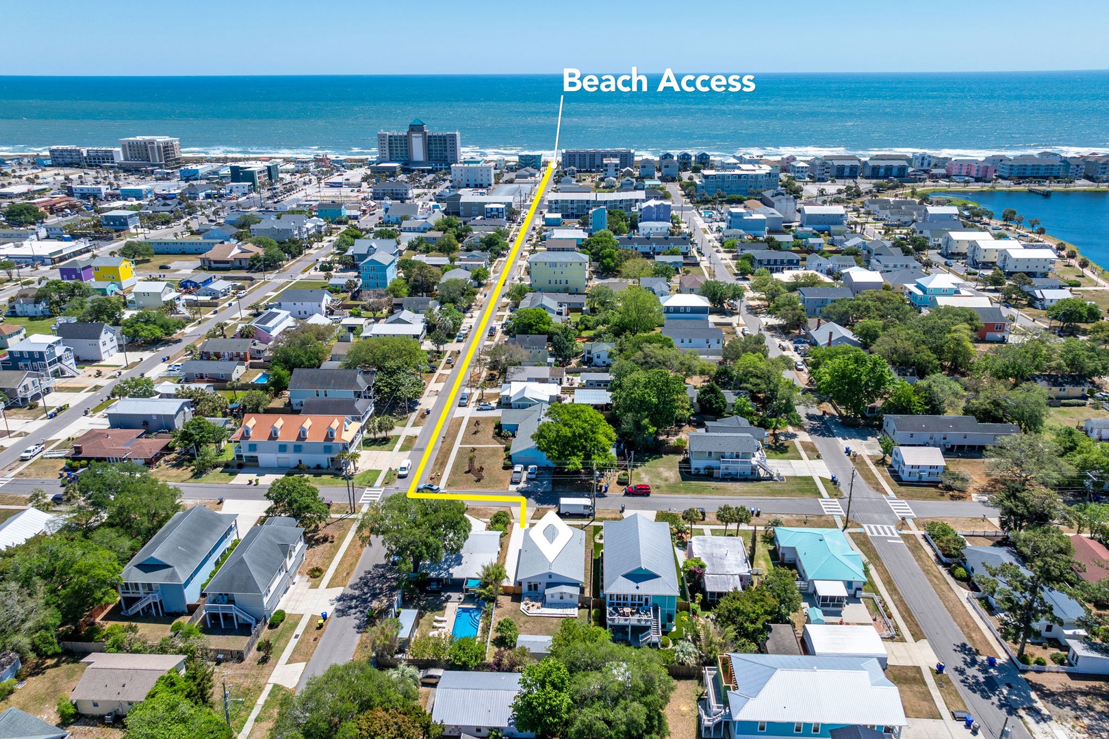 Aerial view of a coastal neighborhood showing direct beach access just steps away from vacation rental properties.