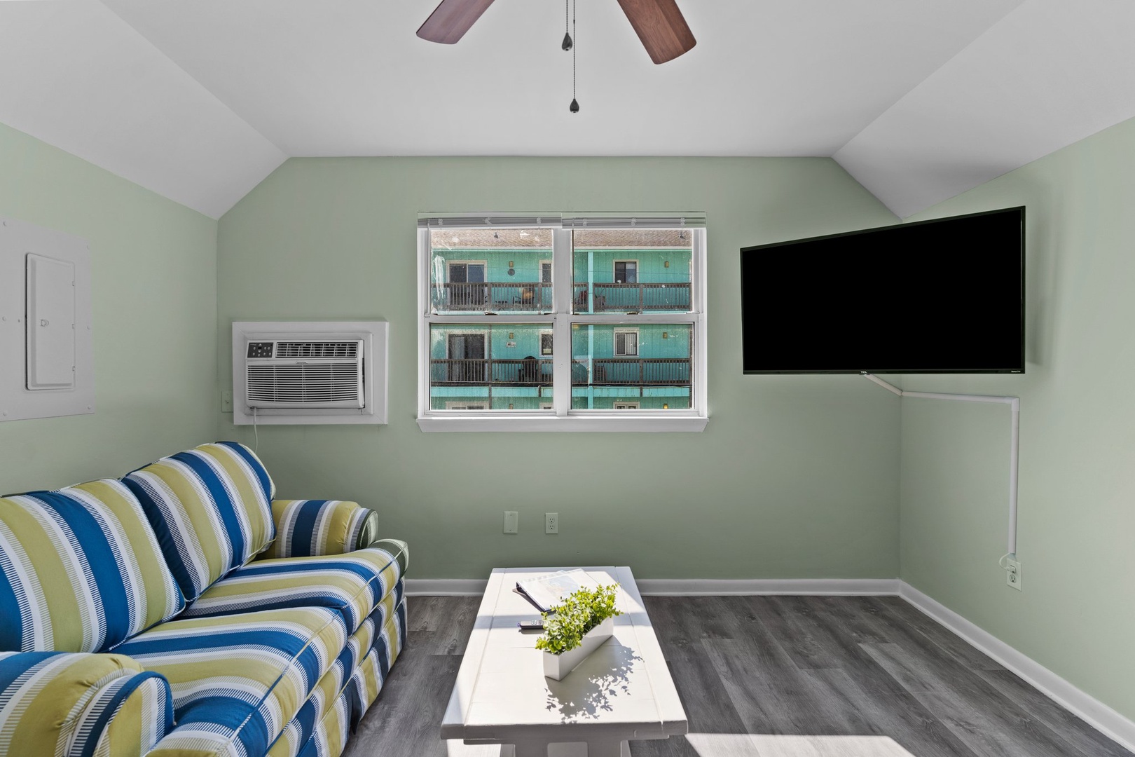 Unwind in your bright living space with cheerful striped seating, flat-screen TV, and cooling AC for total comfort.