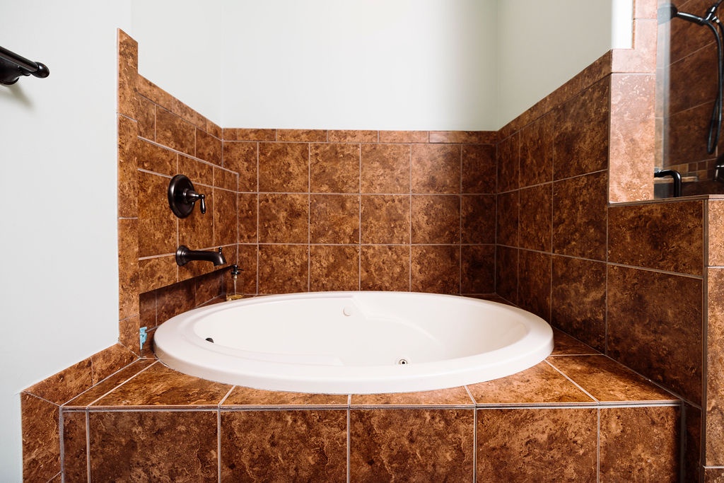 Soak away your day's adventures in this luxurious jetted tub, surrounded by elegant marble tiles for the perfect spa-like retreat.