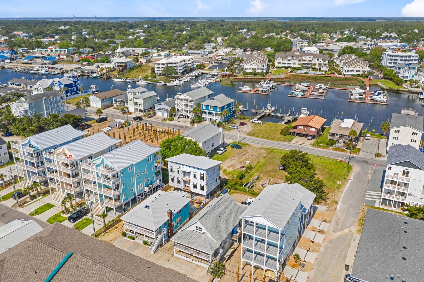 Aerial view showcasing the vibrant waterfront community with colorful beach houses, marina, and peaceful coastal neighborhood.