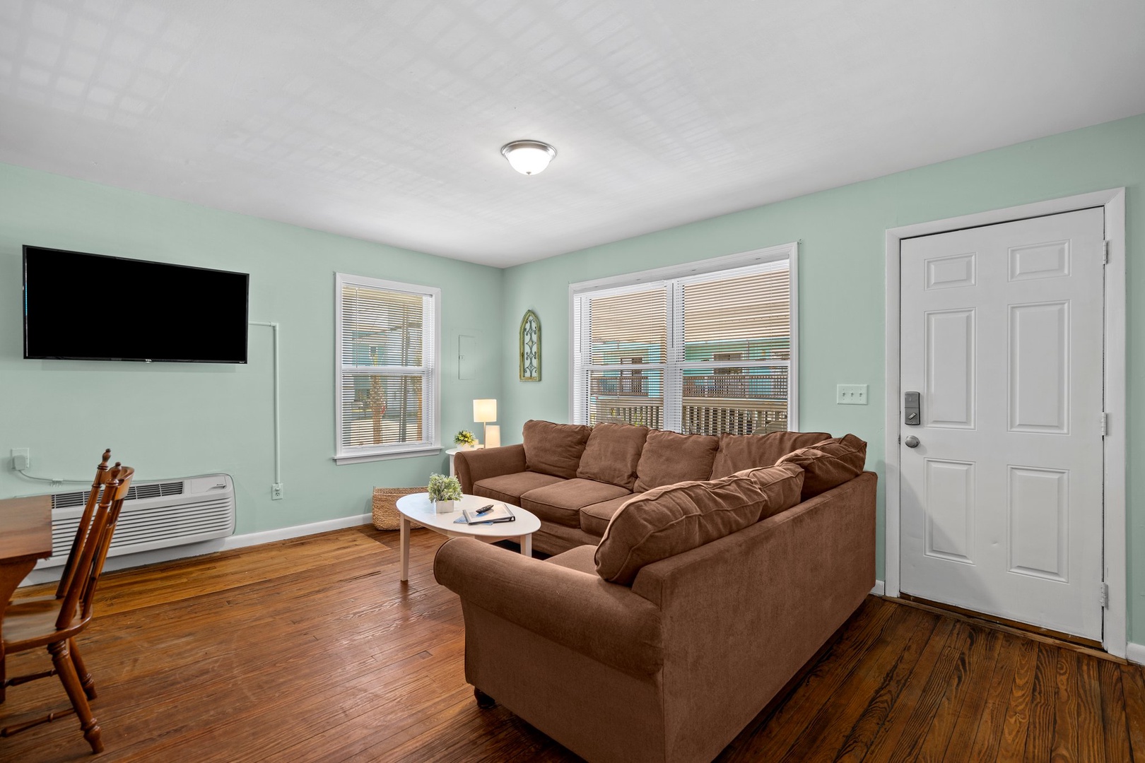 Relax in your cozy living space with comfortable seating and warm hardwood floors beneath your feet.