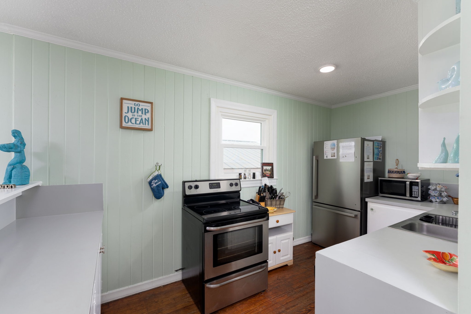 Your coastal kitchen awaits with ocean-themed charm, full appliances, and soothing seafoam walls perfect for preparing memorable vacation meals.