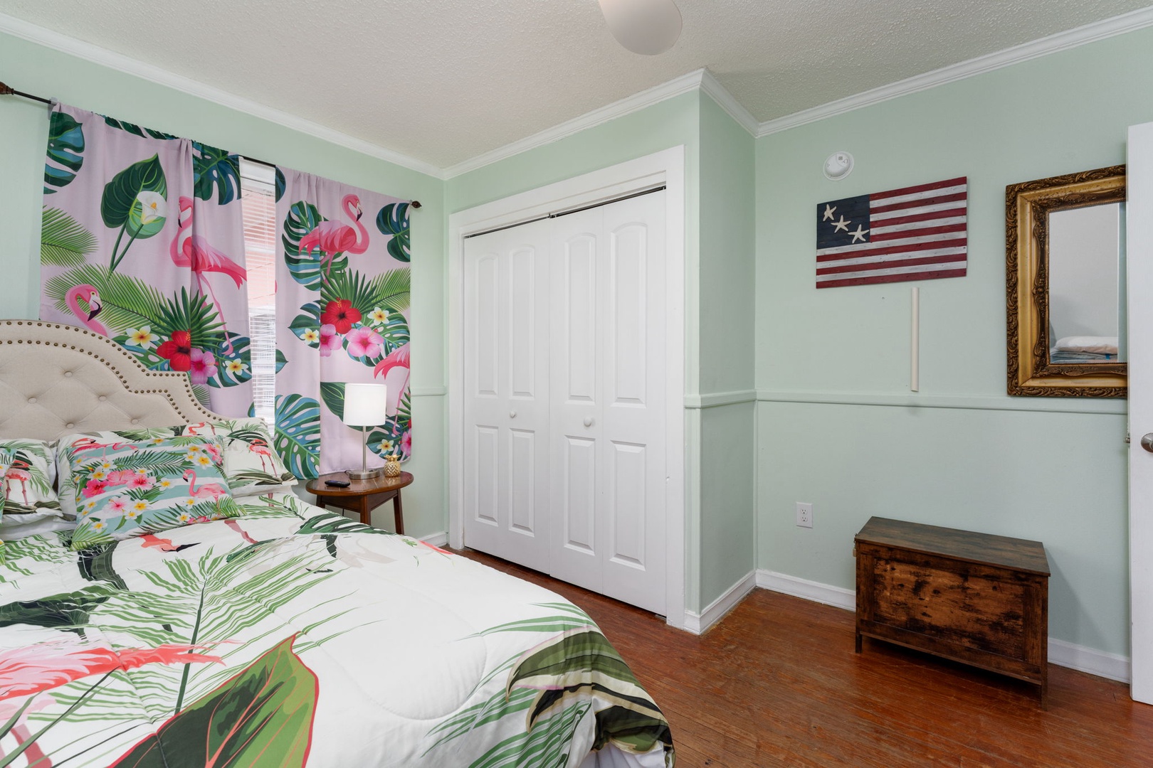 Wake up in your tropical paradise with vibrant flamingo prints and soothing mint walls creating the perfect vacation vibe.