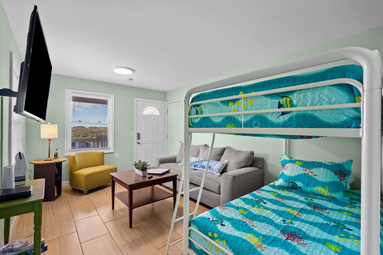 Your family-friendly space features colorful bunk beds with ocean-themed bedding, creating the perfect coastal retreat for kids and adults alike.