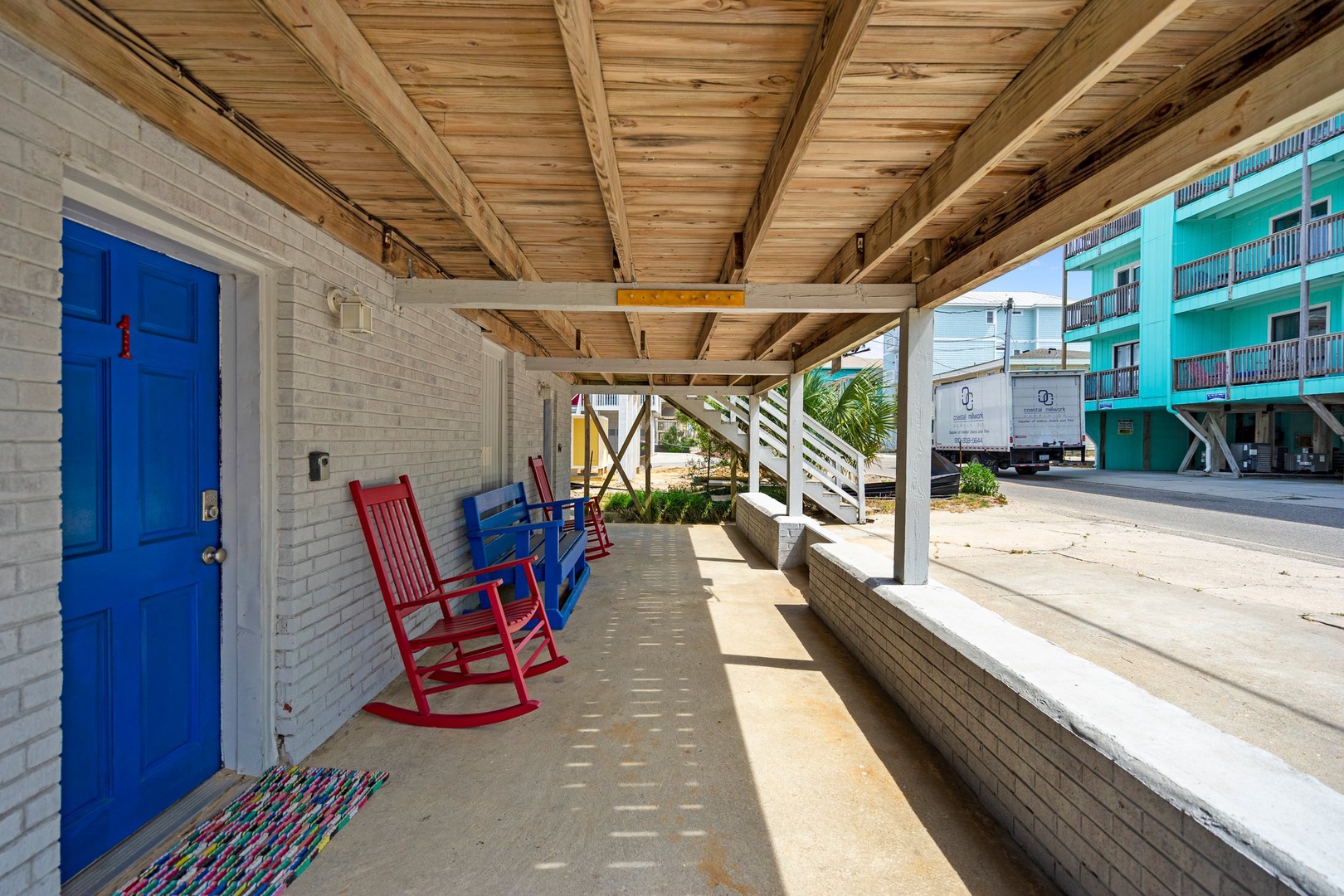 Relax in your colorful rocking chairs on this shaded porch, perfect for sipping morning coffee while watching the coastal town come to life.