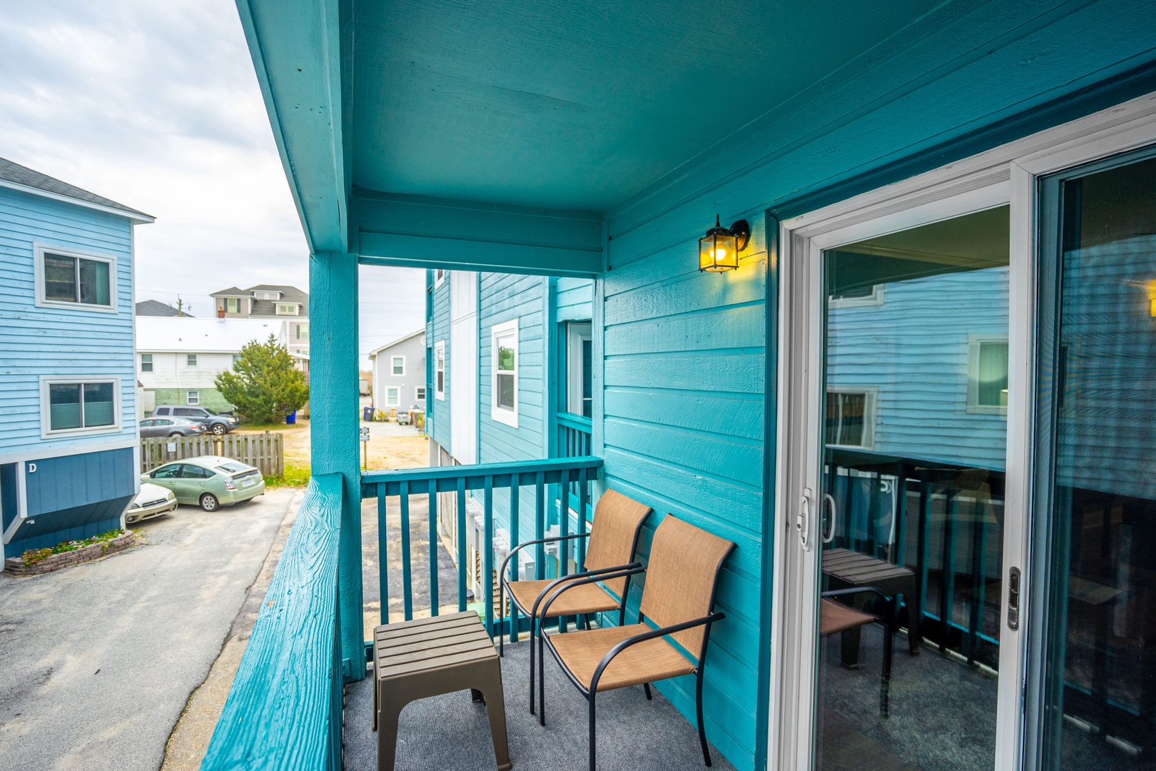 Relax on your private covered balcony with comfortable seating, perfect for morning coffee or evening conversations overlooking the charming neighborhood.