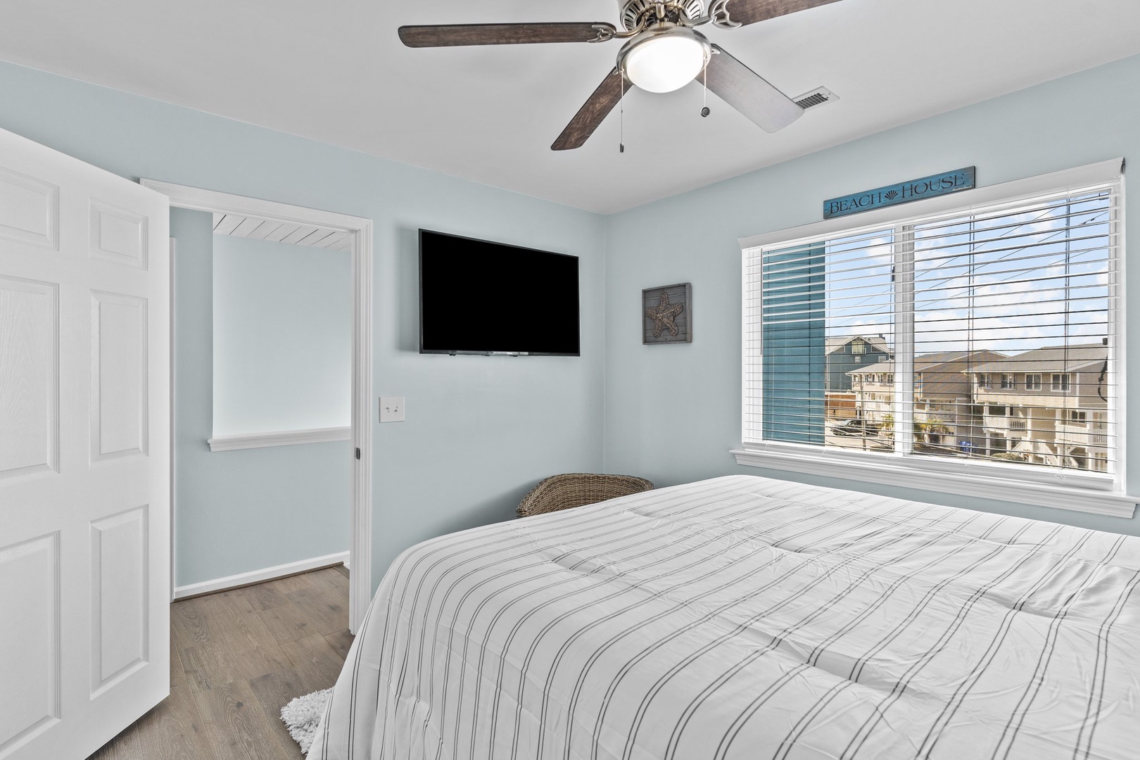 Your peaceful bedroom retreat features soothing coastal colors, a flat-screen TV for movie nights, and refreshing ceiling fan breezes.