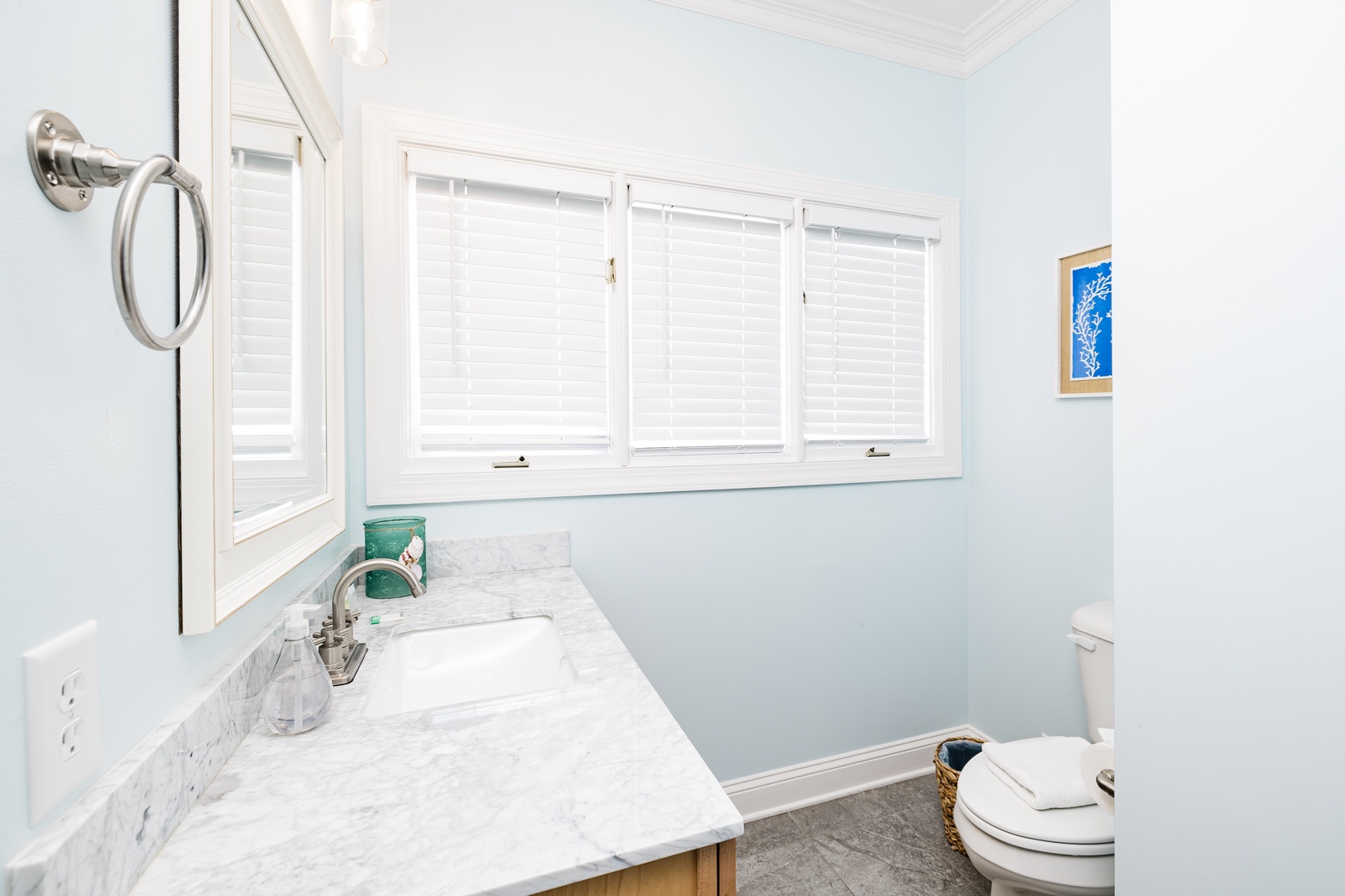 Step into your bright, airy bathroom with elegant marble countertops and soft natural light streaming through plantation shutters.