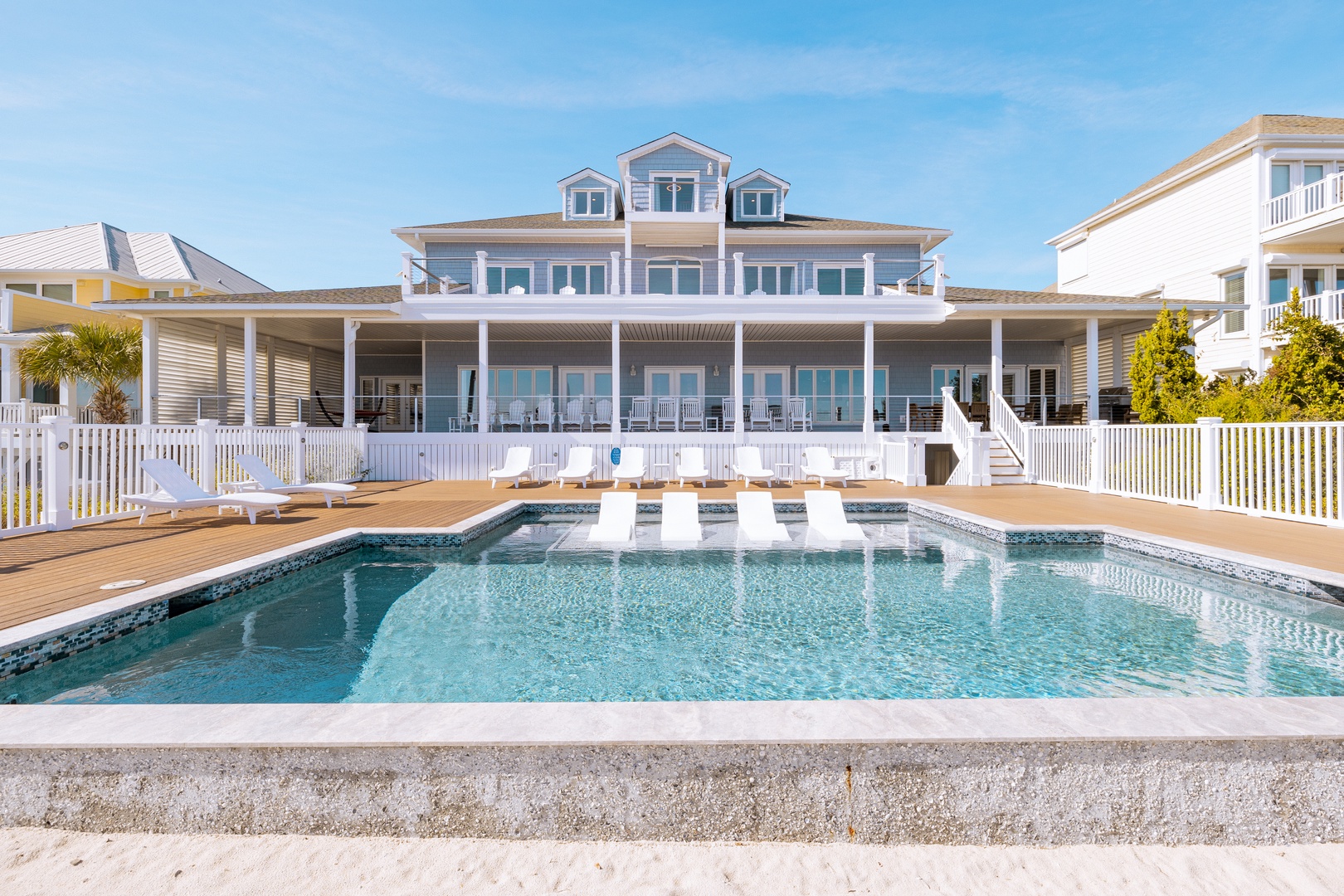 Beautiful beachfront property with sparkling pool and expansive deck for ultimate coastal relaxation.