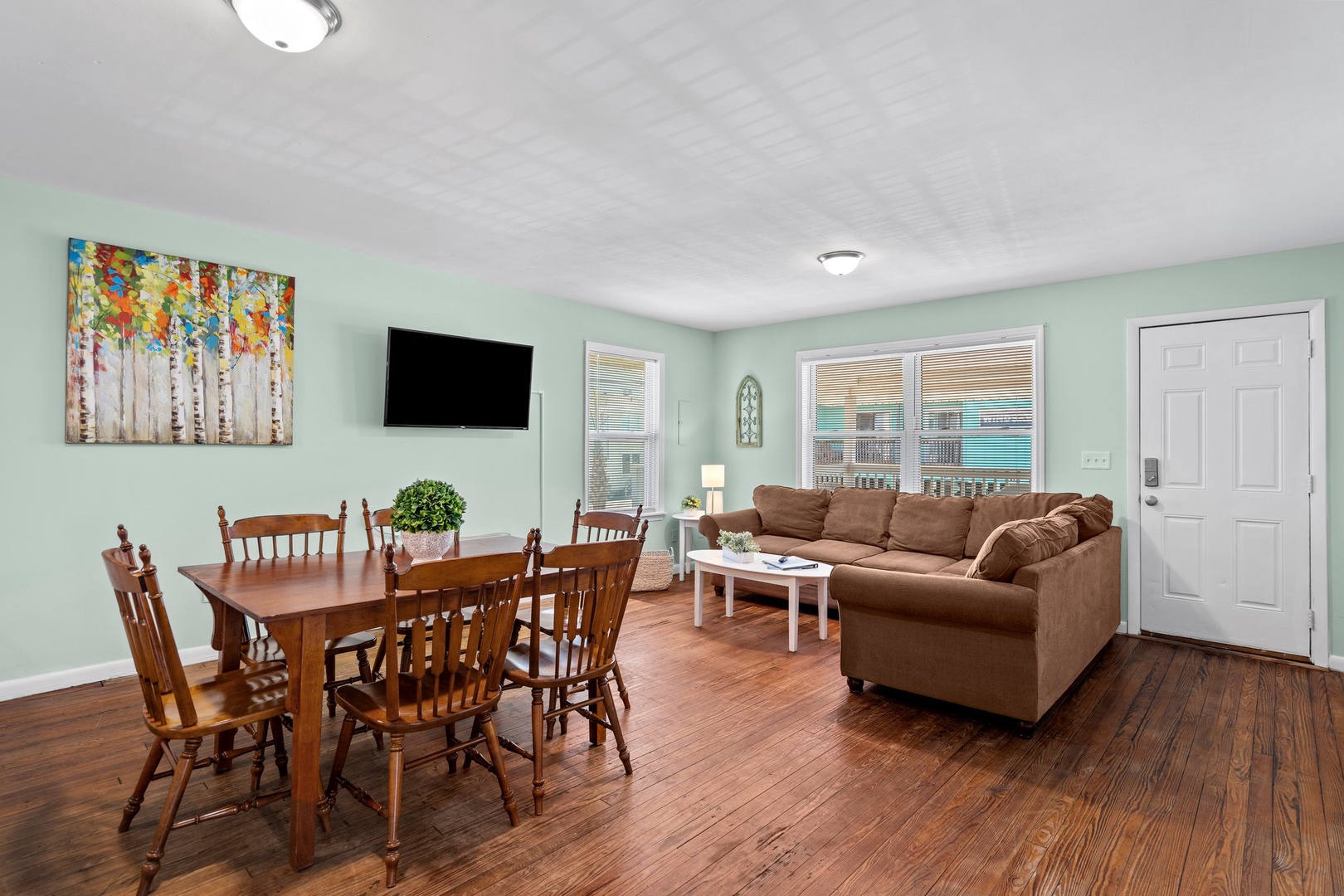 Relax in your spacious open-plan living area with comfortable seating and natural light streaming through large windows.