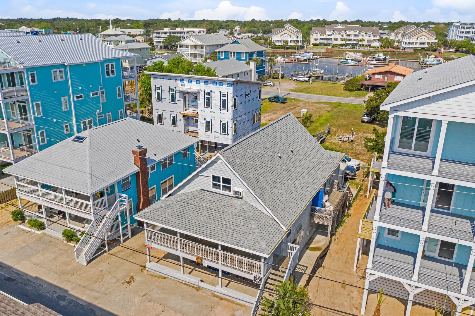Aerial view of a charming coastal neighborhood featuring colorful beach houses and vacation rentals among well-established residential community.