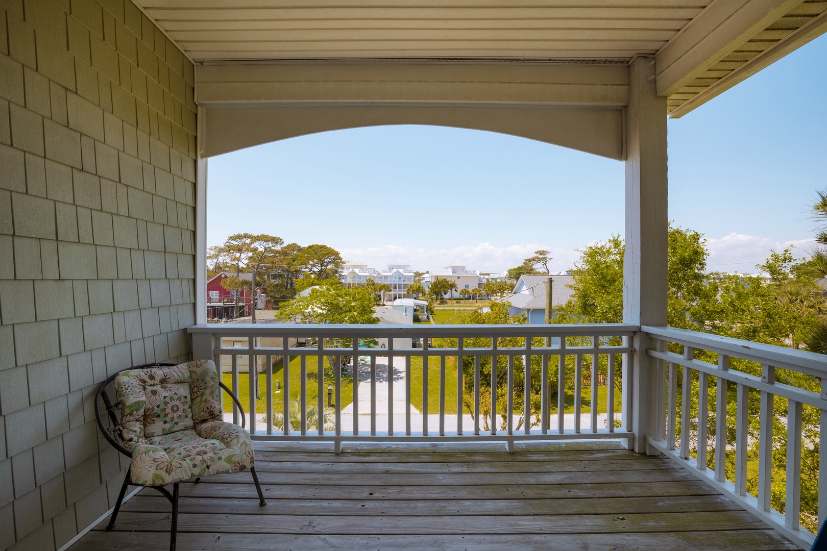 Relax in your private covered balcony with comfortable seating and peaceful neighborhood views through the trees.