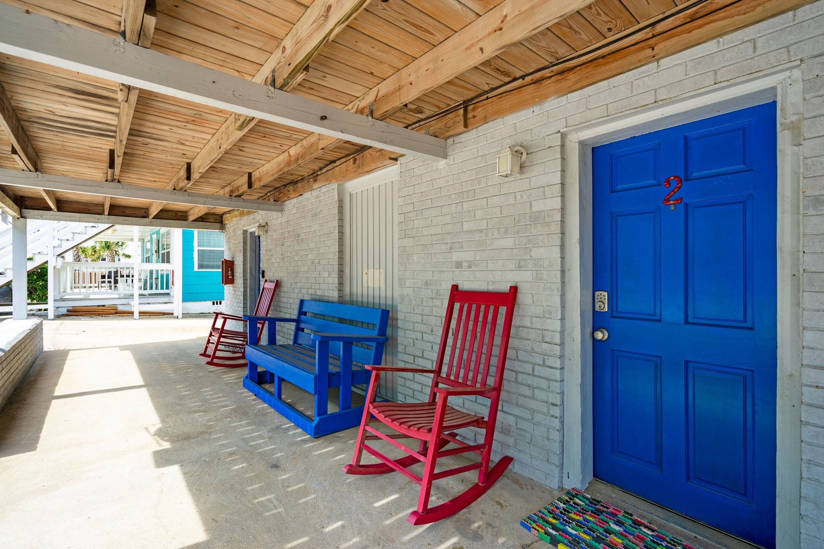 Relax on your covered porch with colorful rocking chairs and a cozy glider bench—perfect for morning coffee or evening conversations.