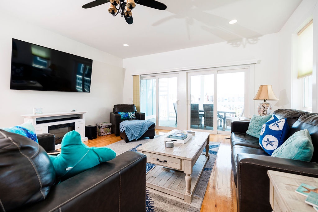 Relax in your bright living room with leather seating, wall-mounted TV, and coastal-themed touches perfect for family movie nights.