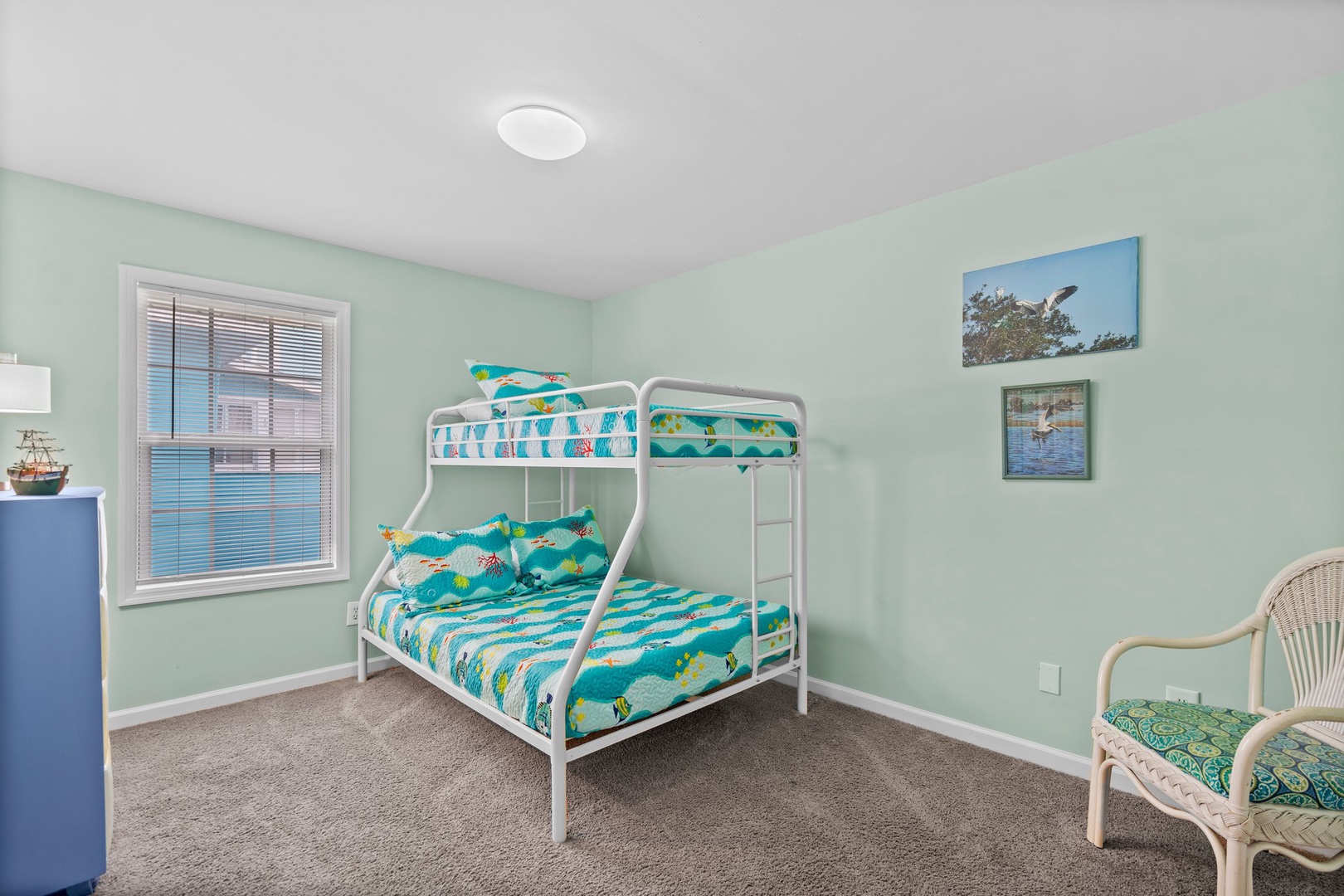 Your kids will love this cheerful ocean-themed bedroom with its twin-over-full bunk bed and coastal artwork creating the perfect sleepover space.