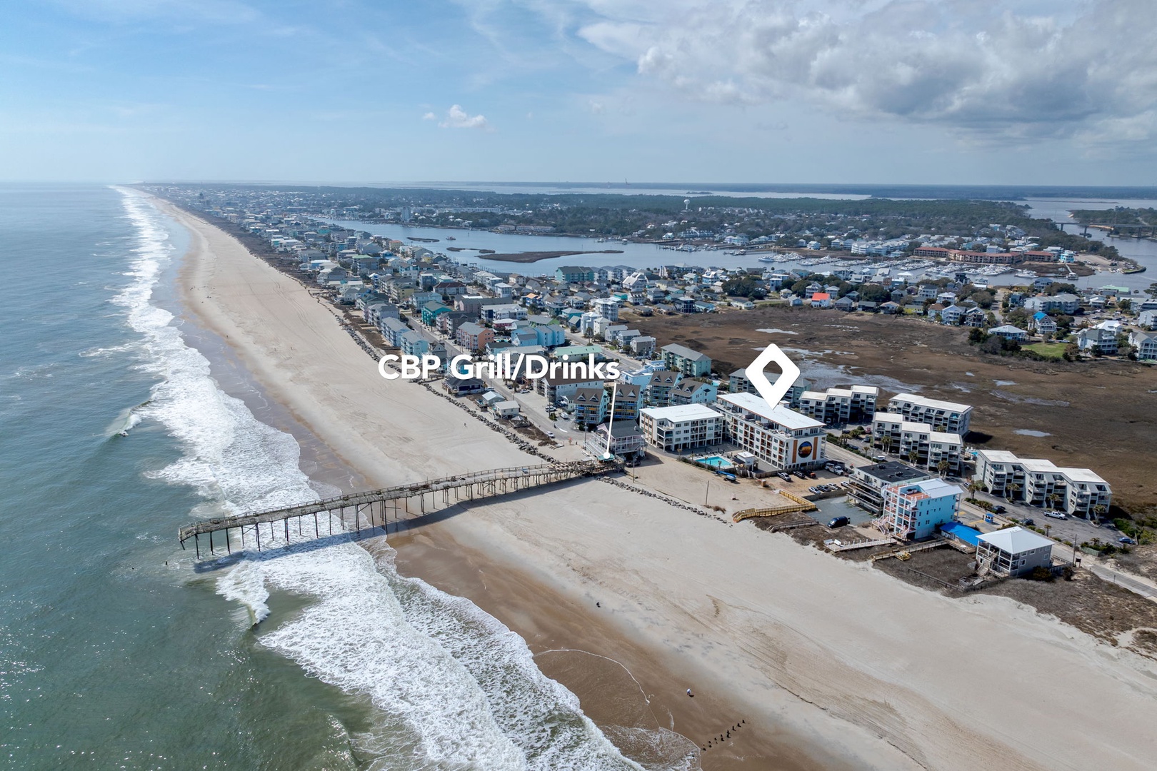 Stunning aerial view of the beachfront property location, showcasing the expansive coastline and nearby pier access.
