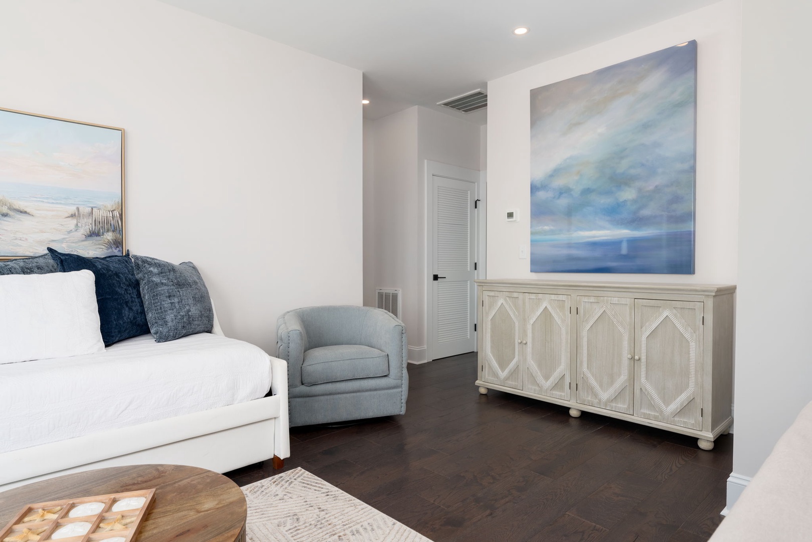 Sink into plush seating while ocean-inspired artwork creates a serene coastal atmosphere in your elegant living space.