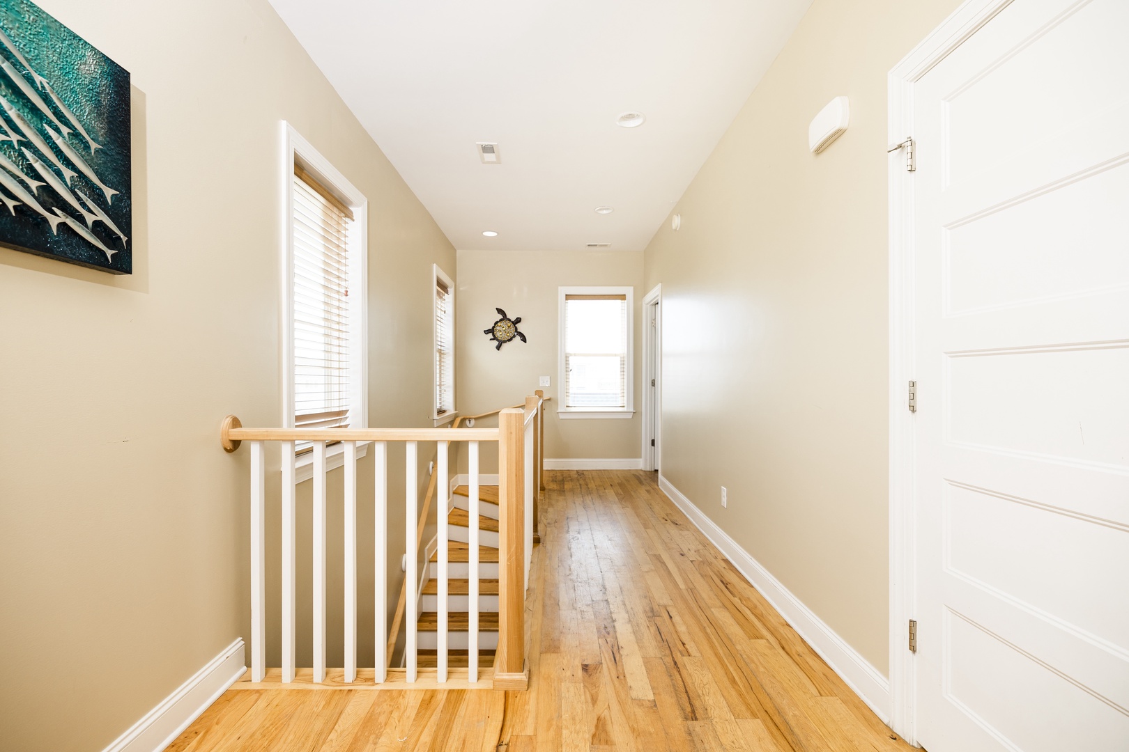 Ascend to your private upstairs retreat where warm hardwood floors and coastal charm create a welcoming haven.