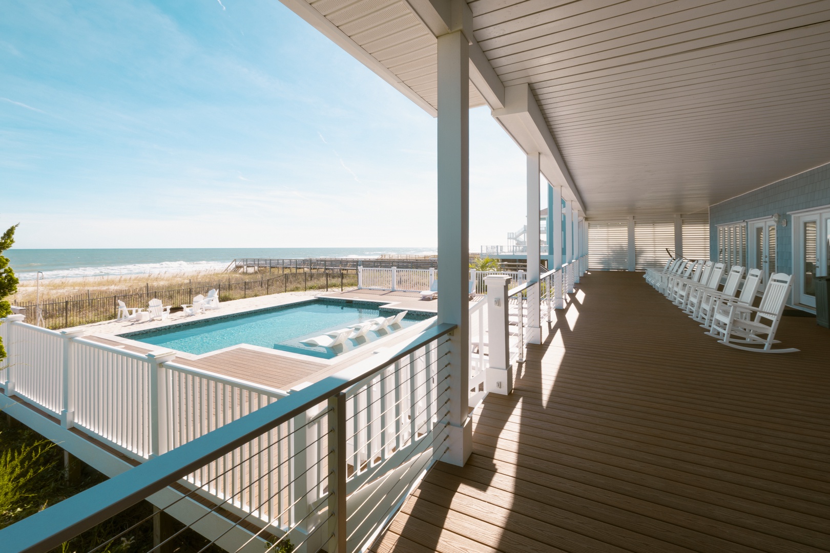 Unwind on your private covered deck overlooking the sparkling pool and pristine beach, perfect for morning coffee and sunset relaxation.