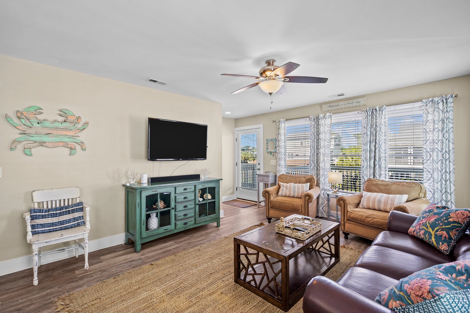 Unwind in your cozy living room with comfortable seating, entertainment center, and charming coastal décor that invites relaxation.