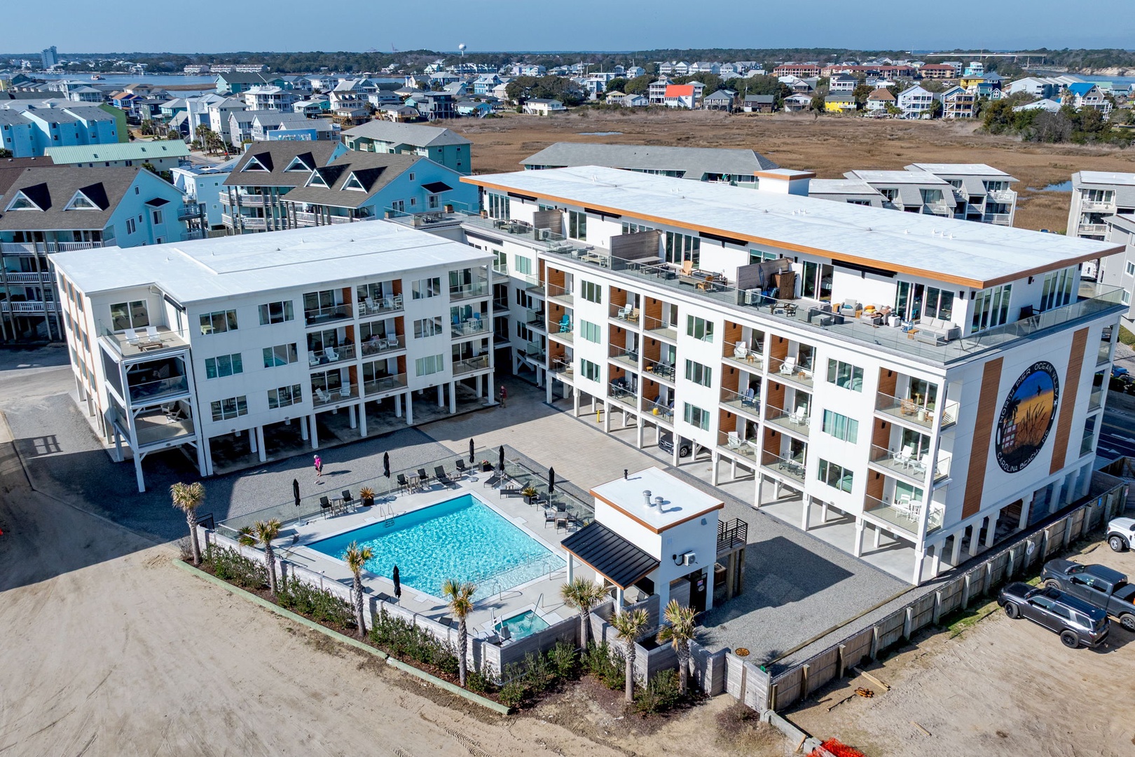 Modern beachside resort complex featuring spacious pool area and contemporary accommodations in a charming coastal community setting.