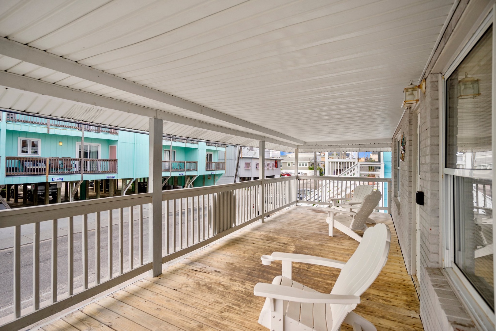 Unwind on your private deck with comfortable seating and charming views of colorful beach houses.